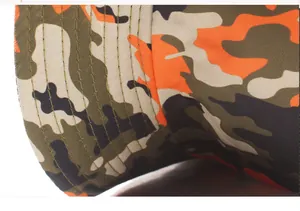 Détail du bord d'un chapeau camouflage avec coutures parallèles sur tissu orange et vert