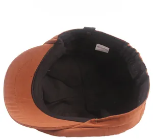 Detail of the 100% cotton label and black lining inside the brown newsboy cap