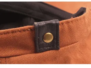 Detail of high-density twill cotton fabric with leather strap and gold metal rivet