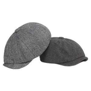 Classic herringbone newsboy caps in grey and charcoal wool fabric on white background