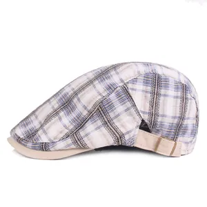 Dettaglio cappello piatto a quadri con fibbia regolabile e bordo color kaki