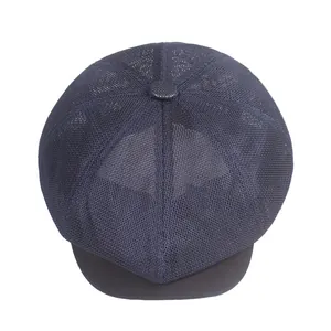 Detailed close-up of dark blue mesh newsboy cap showing breathable ventilation holes