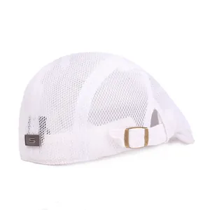 Détail de la casquette en maille blanche avec boucle en bronze et plaque logo en métal