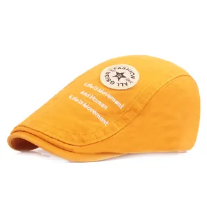 Détail du béret jaune avec broderie étoile et texte Life Is Movement sur le côté