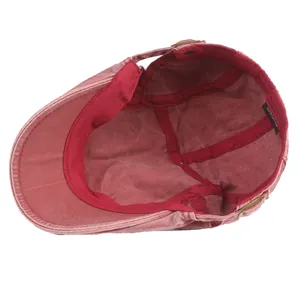Internal view of washed red cotton duckbill cap showing 100% cotton lining and stitching