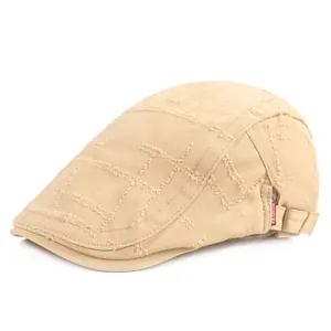 Détail du béret beige avec coutures vieillies et étiquette rouge fashion label