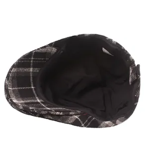 Interior view of black and white plaid wool beret showing inner lining and care label