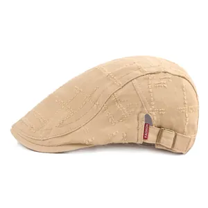 Gros plan du béret en toile beige vieillie avec boucle en métal et étiquette mode