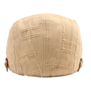 Détail d'une casquette gavroche kaki montrant les bords effilochés et les surpiqûres