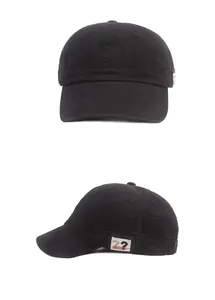 Détail d'une casquette de baseball en coton noir avec écusson décoratif et coutures nettes