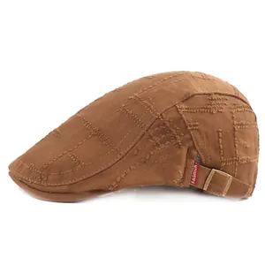 Détail d'un béret marron en toile usée avec étiquette mode et boucle métallique