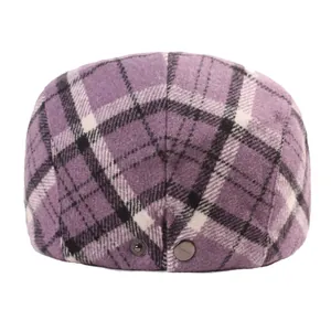 Detail shot of the purple plaid wool beret with two dark gunmetal buttons on the back