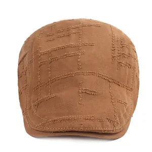 Détail du béret en coton marron avec bords effilochés usés et coutures décoratives