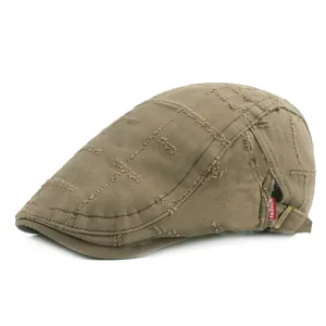 Détail de la casquette en toile kaki avec bords effilochés et boucle en métal réglable