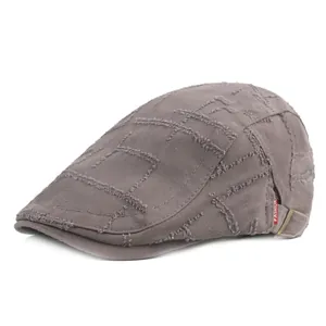 Béret gris-violet délavé avec bords effilochés et étiquette de mode sur fond blanc pur