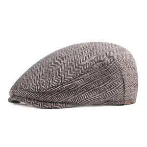 Detail of herringbone wool fabric and brown leather label on the flat cap