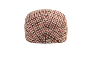 Close-up of vintage houndstooth pattern and metal snap button on a woolen beret
