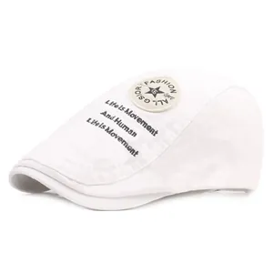 Détail de la casquette plate blanche avec écusson étoile et broderie latérale