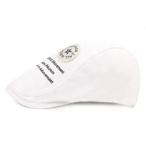 Détail de la casquette plate en toile blanche avec écusson étoile et broderies latérales
