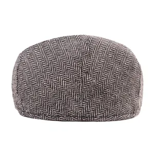 Close-up of classic herringbone tweed fabric and high-quality stitching on the newsboy cap