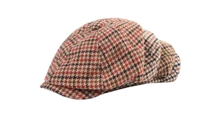 Macro detail of the vintage striped pattern and thick tweed texture of the flat newsboy cap
