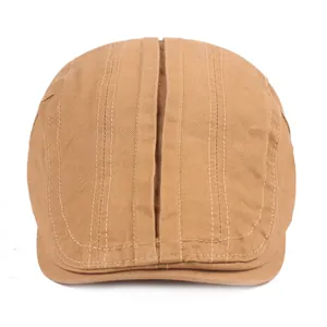 Détail d'une casquette plate kaki avec des surpiqûres décoratives et tissu en coton mat