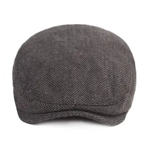 Classic dark grey herringbone flat cap made of warm wool blend fabric in vintage style