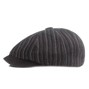Detail view of black striped newsboy cap with white pinstripes and top button