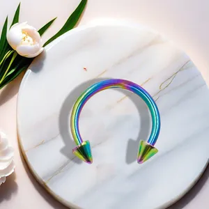 Macro detail of a rainbow-coated stainless steel horseshoe nose ring with spike ends