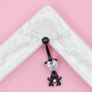 Macro shot of black spider pendant with heart-shaped zircon and bat-style navel piercing