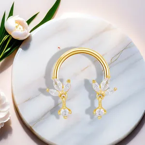 Detailed macro of golden horseshoe ring with marquise zircon leaf accents on marble