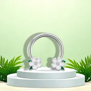 Close-up of a stainless steel horseshoe nose ring with white camellia flower accents