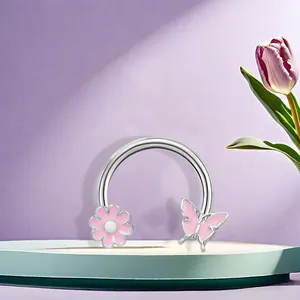Horseshoe piercing ring with pink enamel flower and butterfly on a decorative stand