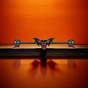 Détail du piercing industriel gothique avec crâne noir et gemme de cœur rouge