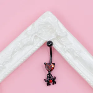 Detail of gothic spider navel ring with red heart zircon on curved black barbell