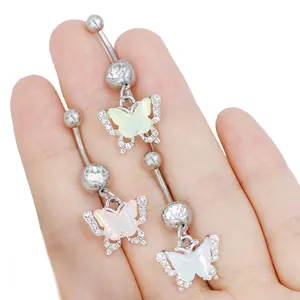 Primer plano de piercings de ombligo de mariposa con circonitas y alas de nácar irisado