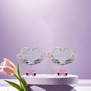 Titanium swan heart nipple rings with pink bells on a soft purple display stand
