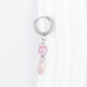 Detalle de pendiente plateado con circonita rosa y colgante de gota facetada brillante
