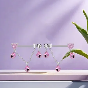 Close-up of titanium nipple ring with pink heart stones and dangling mini bells