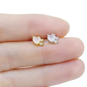 Macro shot of tiny pink heart gemstone labret stud on fingertip to show mini scale