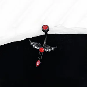 Gros plan du piercing nombril gothique noir avec ailes en cristal rouge et pendentif goutte