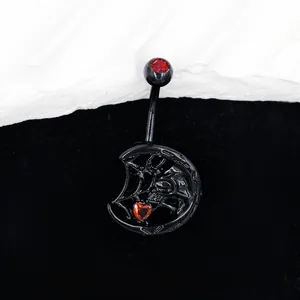 Détail macro d'un piercing de nombril gothique avec zircon en cœur et motif lune toile