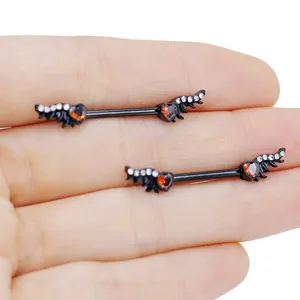 Close-up of black matte stainless steel nipple rings with red heart gems and winged wings