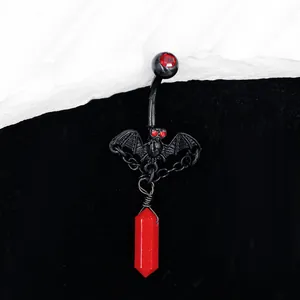 Détail macro d'un piercing de nombril gothique chauve-souris avec pendentif cristal rouge