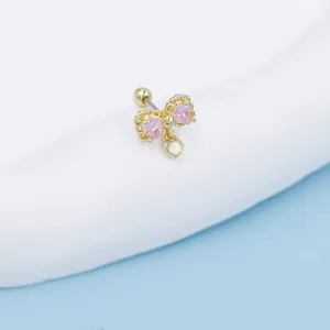 Detailaufnahme goldener Schleifen-Ohrstecker mit rosa Herz-Zirkonia und Herzanhänger