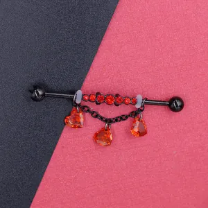 Detail of black industrial barbell with red heart pendants and fine chain link jewelry
