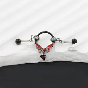 Macro detail of gothic bat earring with red heart pendant and black hoop jewelry