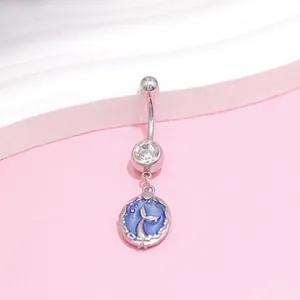 Macro detail of stainless steel belly ring with mermaid tail blue enamel pendant