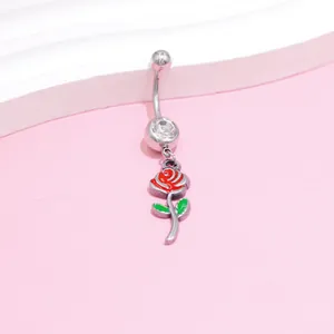 Macro detail of stainless steel navel ring featuring red rose pendant and clear zircon stone