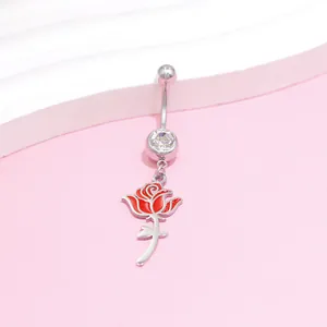 Macro shot of stainless steel navel ring with red rose pendant and zircon stone